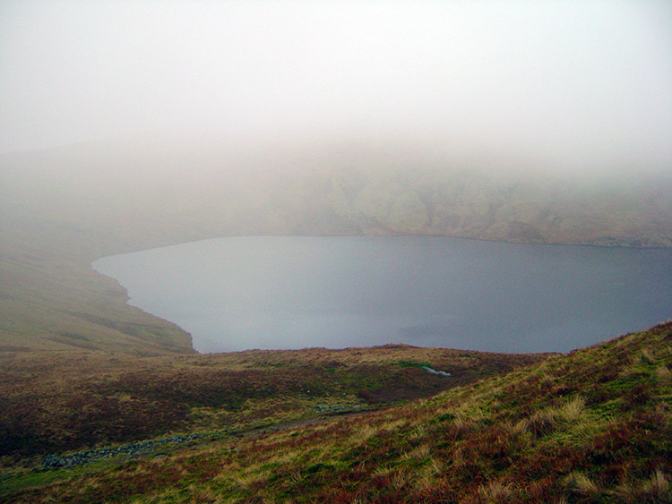 Grisedale Tarn briefly appears through the mist